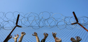 Immigrants lean on the fences during an unrest inside Pagani detention centre, in the eastern Aegean island of Lesvos